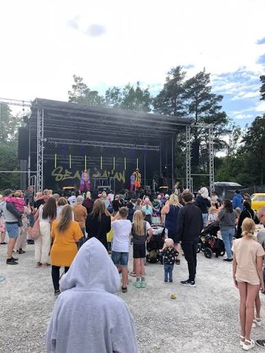 Publik framför en utomhusscen bland tallarna